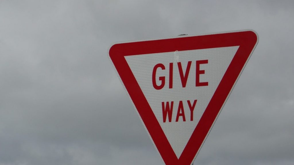 a red and white sign that says give way